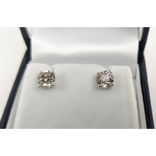 45 - A PAIR OF 18CT WHITE GOLD DIAMOND SOLITAIRE STUD EARRINGS, each with a claw set round brilliant cut ... 