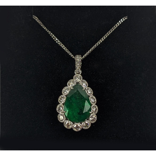 48 - AN 18CT WHITE AND YELLOW METAL EMERALD AND DIAMOND PENDANT NECKLACE, the pendant with a pear-shaped ... 