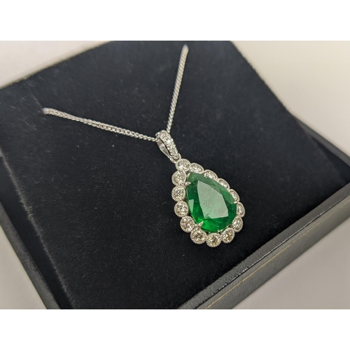 48 - AN 18CT WHITE AND YELLOW METAL EMERALD AND DIAMOND PENDANT NECKLACE, the pendant with a pear-shaped ... 