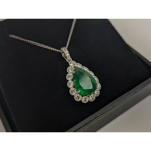 48 - AN 18CT WHITE AND YELLOW METAL EMERALD AND DIAMOND PENDANT NECKLACE, the pendant with a pear-shaped ... 