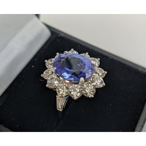 32 - AN 18CT WHITE GOLD TANZANITE AND DIAMOND CLUSTER RING, the central mixed cut stone of 4.95 carats, s... 