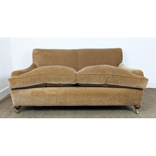 584 - HOWARD STYLE SOFA, tan coloured velvet on brass castors, 77cm H x 165cm W x 97cm D.