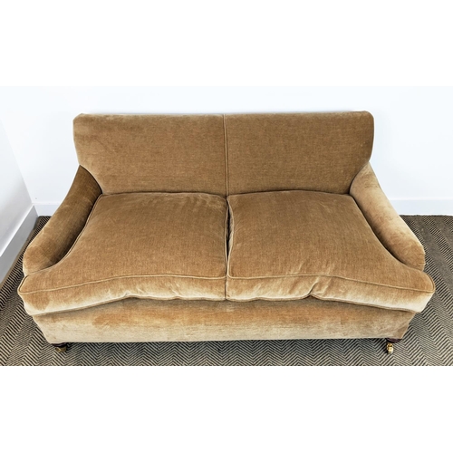 584 - HOWARD STYLE SOFA, tan coloured velvet on brass castors, 77cm H x 165cm W x 97cm D.