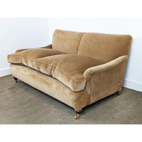 584 - HOWARD STYLE SOFA, tan coloured velvet on brass castors, 77cm H x 165cm W x 97cm D.