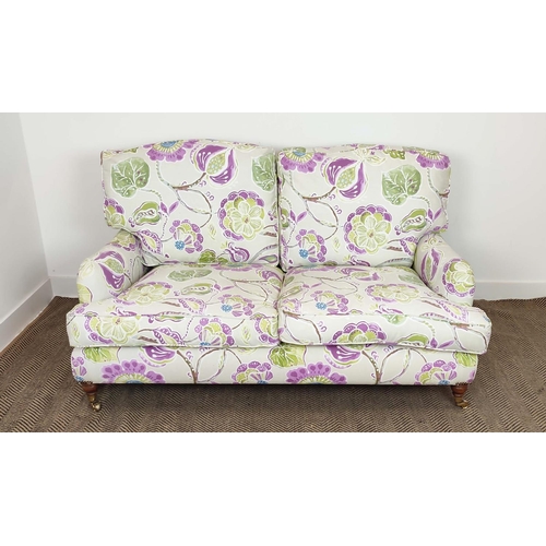 223 - SOFA, purple and green floral patterned on brass castors, 90cm H x 160cm W.