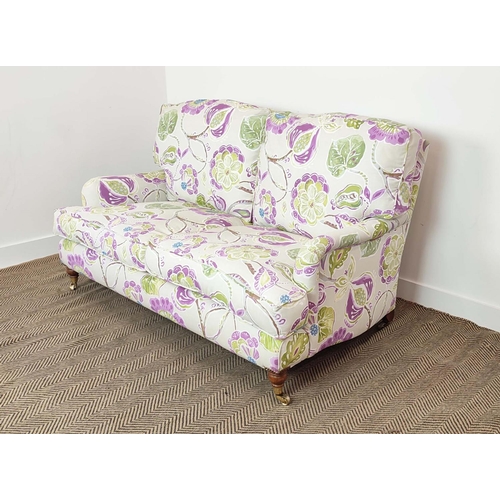 223 - SOFA, purple and green floral patterned on brass castors, 90cm H x 160cm W.