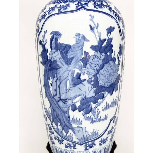 104 - PEACOCK VASE ON STAND, large Chinese ceramic blue and white peacock vase on carved wood stand, 77cm ... 