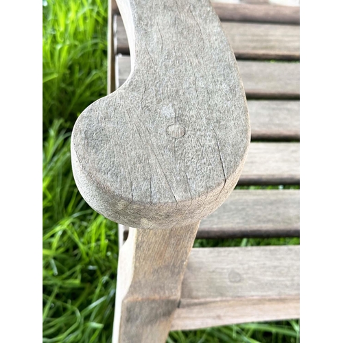 137 - GARDEN BENCH BY 'BRIDGMAN AND CO', well weathered teak slatted with shaped yoke and shaped flat top ... 