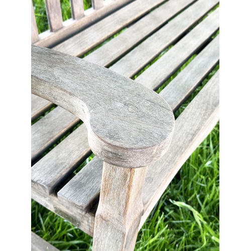 137 - GARDEN BENCH BY 'BRIDGMAN AND CO', well weathered teak slatted with shaped yoke and shaped flat top ... 