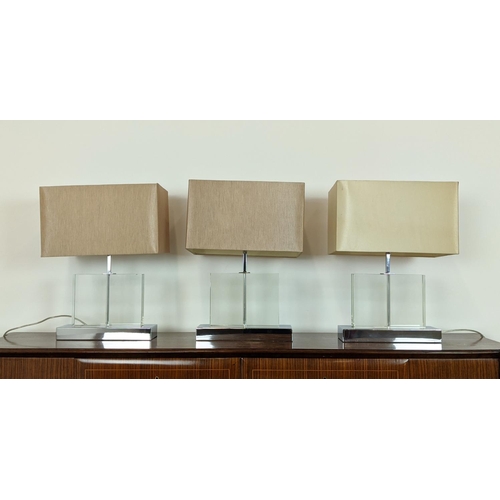 544 - TABLE LAMPS, a set of three, glass on polished metal bases, each 52cm H overall including shades. (3... 