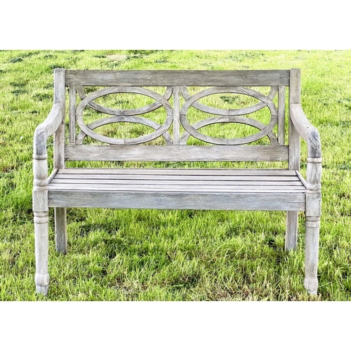 104 - COLONIAL STYLE GARDEN BENCH, well weathered teak with pierced oval panels and downswept arms, 113cm ... 