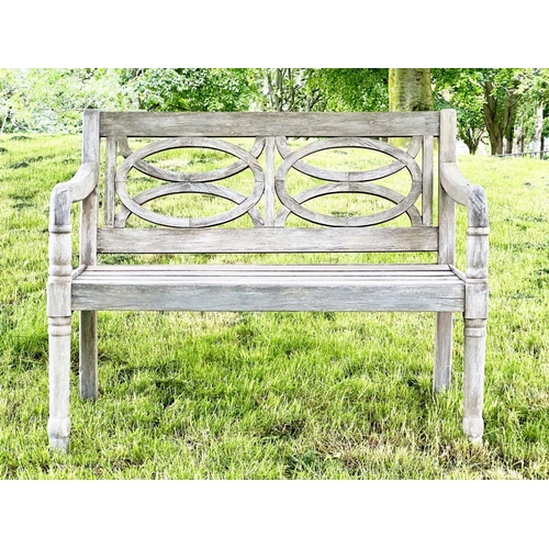 104 - COLONIAL STYLE GARDEN BENCH, well weathered teak with pierced oval panels and downswept arms, 113cm ... 