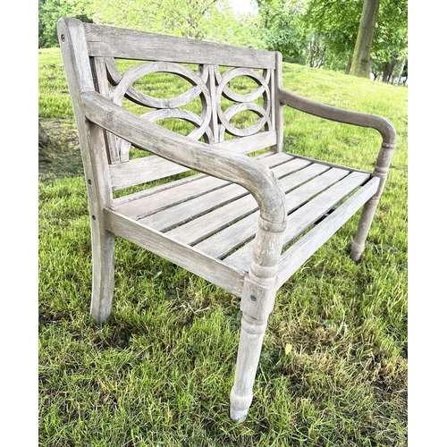 104 - COLONIAL STYLE GARDEN BENCH, well weathered teak with pierced oval panels and downswept arms, 113cm ... 