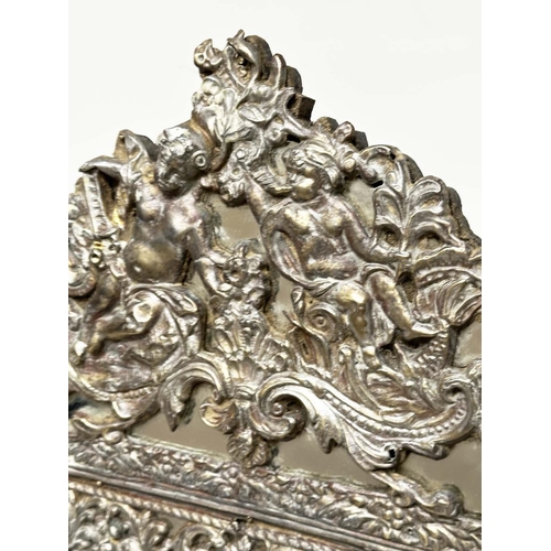 97 - WALL MIRROR, 19th century Flemish repoussé silvered metal and ebonised with cushion and bevelled mar... 