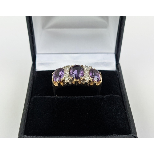 18 - A 9CT GOLD AMETHYST AND DIAMOND DRESS RING, set with three mixed cut amethysts with diamond set spac... 