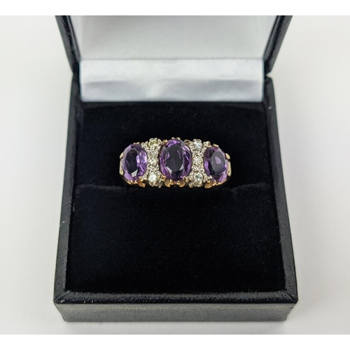 18 - A 9CT GOLD AMETHYST AND DIAMOND DRESS RING, set with three mixed cut amethysts with diamond set spac... 