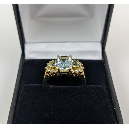 22 - AN 18CT GOLD AQUAMARINE AND DIAMOND SET DRESS RING, set with one large aquamarine and two smaller st... 