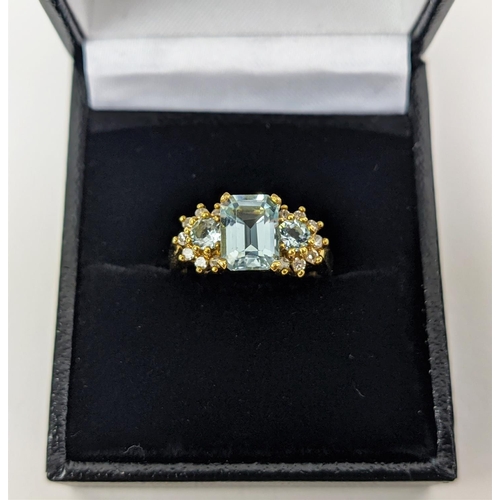 22 - AN 18CT GOLD AQUAMARINE AND DIAMOND SET DRESS RING, set with one large aquamarine and two smaller st... 