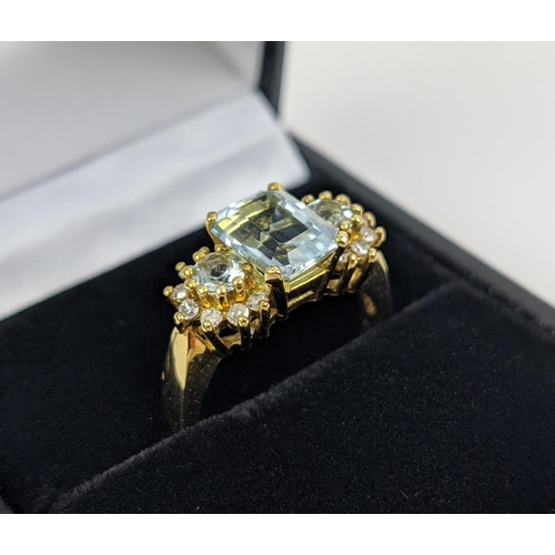 22 - AN 18CT GOLD AQUAMARINE AND DIAMOND SET DRESS RING, set with one large aquamarine and two smaller st... 