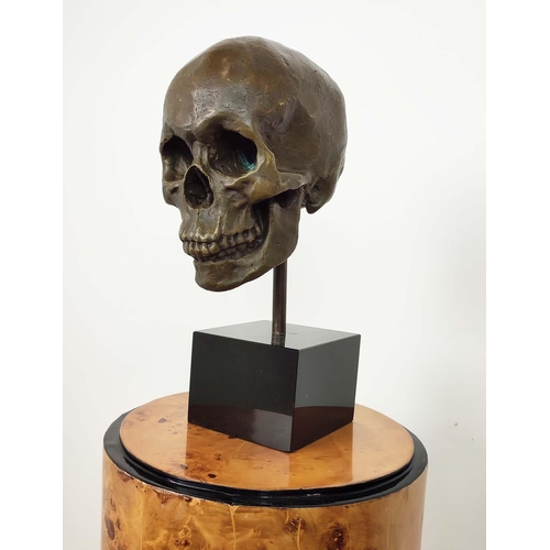 437 - CONTEMPORARY SCHOOL SCULPTURE, of a skull on a black base, 36cm H.