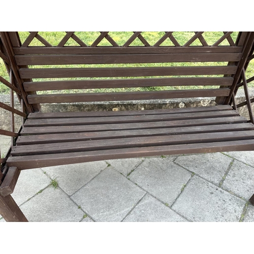 253 - GARDEN GAZEBO, vintage with pitched gable roof trellis back and slatted seat with cushion, 220cm H x... 