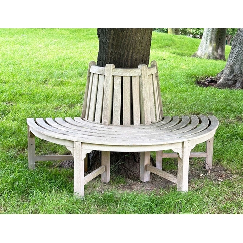 156 - GARDEN TREE BENCH, nicely weathered teak of demilune form, 90cm H x 151cm W x 42cm D.