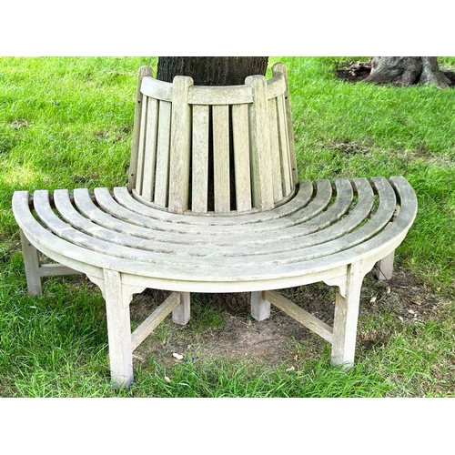 156 - GARDEN TREE BENCH, nicely weathered teak of demilune form, 90cm H x 151cm W x 42cm D.