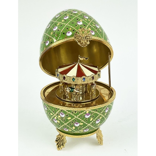 107 - MUSICAL FABERGE EGG, number 25, green and gilt ceramic with hand painted rose decoration, hinged lid... 