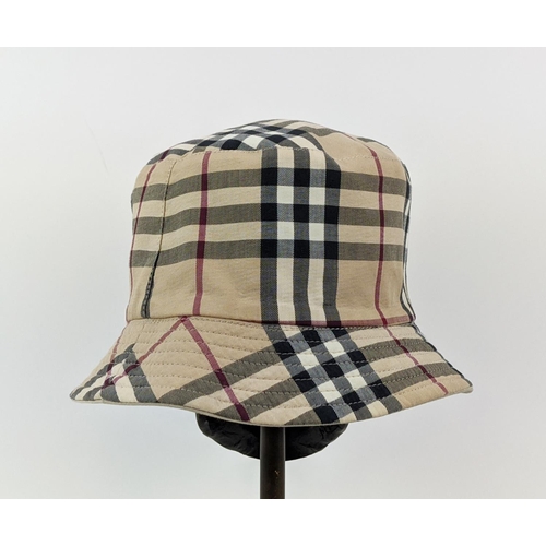 12 - BURBERRY UNISEX REVERSIBLE BUCKET HAT, iconic Burberry check pattern on one side and beige on the ot... 