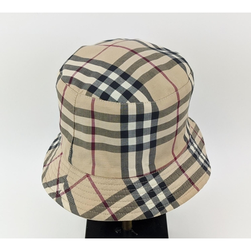 12 - BURBERRY UNISEX REVERSIBLE BUCKET HAT, iconic Burberry check pattern on one side and beige on the ot... 