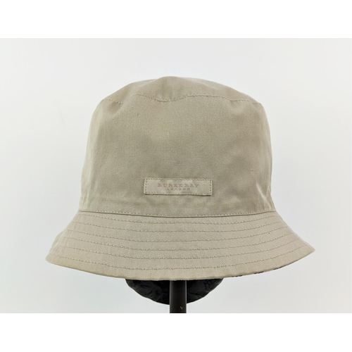 12 - BURBERRY UNISEX REVERSIBLE BUCKET HAT, iconic Burberry check pattern on one side and beige on the ot... 