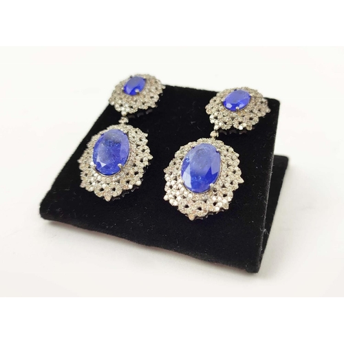 153 - A PAIR OF EDWARDIAN STYLE TANZANITE AND DIAMOND SET DROP EARRINGS, set with four oval
facet cut tanz... 