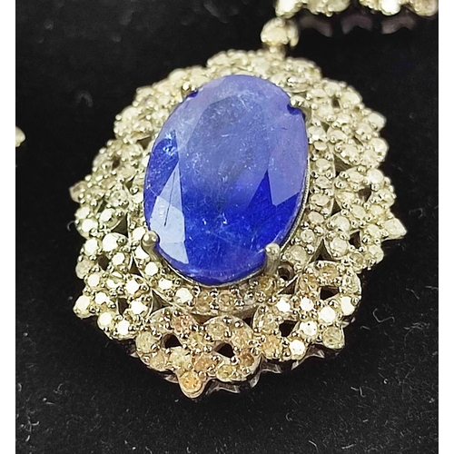 153 - A PAIR OF EDWARDIAN STYLE TANZANITE AND DIAMOND SET DROP EARRINGS, set with four oval
facet cut tanz... 