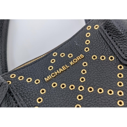 32 - MICHAEL KORS HANDBAG, black leather with front gold tone pattern design, gold tone hardware, two top... 