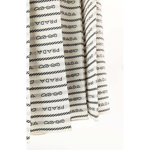 9 - PRADA PLEATED SKIRT, off white silk crepe with rows of 'Prada' lettering and logo throughout, unline... 