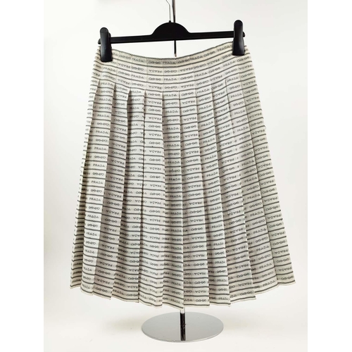 9 - PRADA PLEATED SKIRT, off white silk crepe with rows of 'Prada' lettering and logo throughout, unline... 