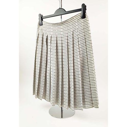 9 - PRADA PLEATED SKIRT, off white silk crepe with rows of 'Prada' lettering and logo throughout, unline... 