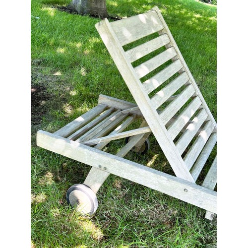 143 - GARDEN LOUNGER BY LINDSEY, well weathered teak slatted and hinged with wheels, drinks tray and cushi... 