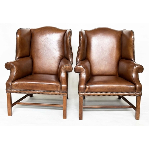 109 - WINGBACK ARMCHAIRS, a pair, George II style mahogany with hand finished brass studded antique soft b... 