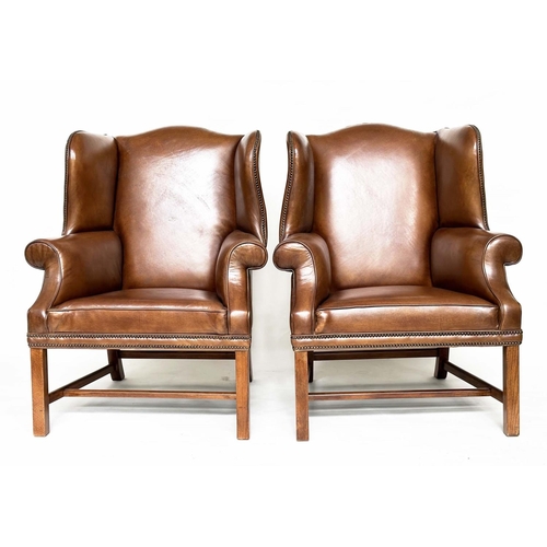 109 - WINGBACK ARMCHAIRS, a pair, George II style mahogany with hand finished brass studded antique soft b... 