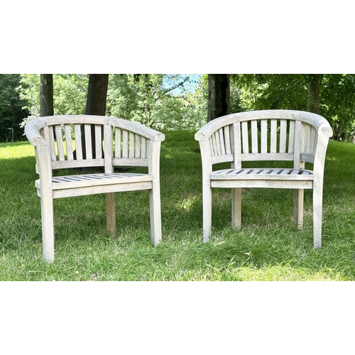 135 - BANANA GARDEN ARMCHAIRS, a pair, well weathered teak with slatted and pegged construction and rounde... 