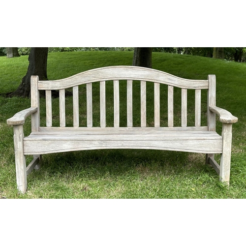 131 - SWAN HATTERSLEY GARDEN BENCH, weathered slatted teak with arched back and flat top shaped arms, 161c... 