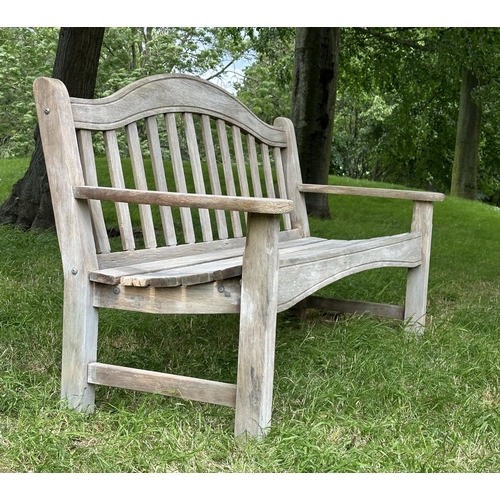 131 - SWAN HATTERSLEY GARDEN BENCH, weathered slatted teak with arched back and flat top shaped arms, 161c... 