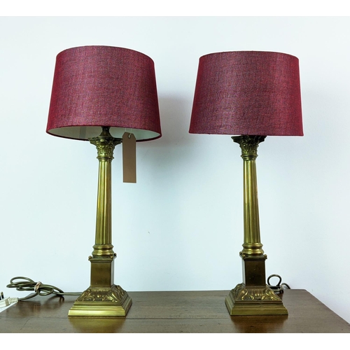 144 - LAMPS, a pair, Corinthian brass columns with red shades, 62cm H. (2)