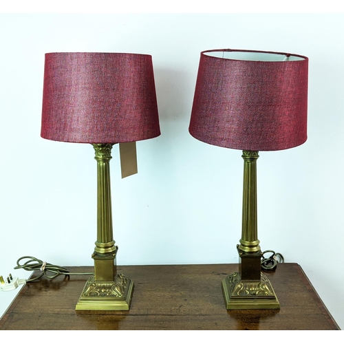 144 - LAMPS, a pair, Corinthian brass columns with red shades, 62cm H. (2)