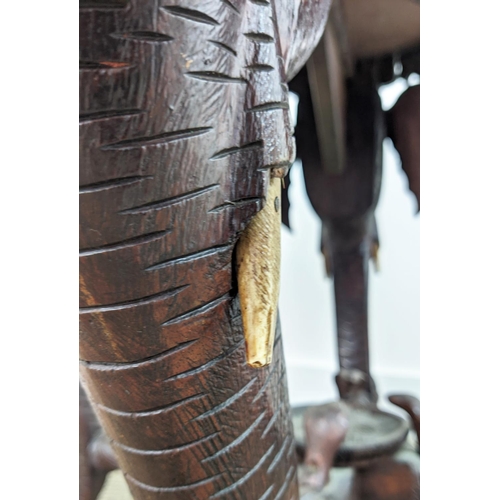 140 - LOW TABLE, early 20th century Indian teak with circular top on elephant carved legs, 62cm H x 74cm W... 