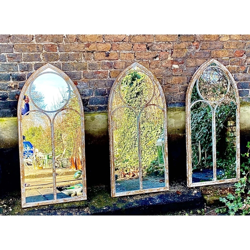 355 - ARCHITECTURAL GARDEN WALL MIRRORS, a set of three, aged metal arched frames, 122cm H x 56ckm W. (3)