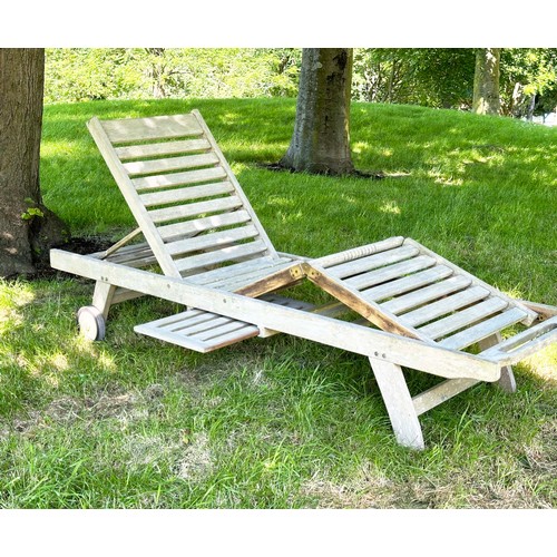 199 - GARDEN LOUNGER BY LINDSEY, well weathered teak slatted and hinged with wheels, drinks tray and cushi... 