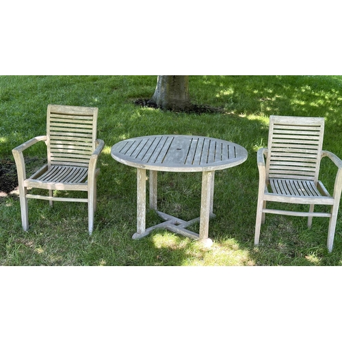 119 - GARDEN ARMCHAIRS, a pair, well weathered teak each stacking with shaped arms together with a circula... 