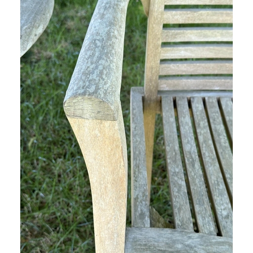 119 - GARDEN ARMCHAIRS, a pair, well weathered teak each stacking with shaped arms together with a circula... 